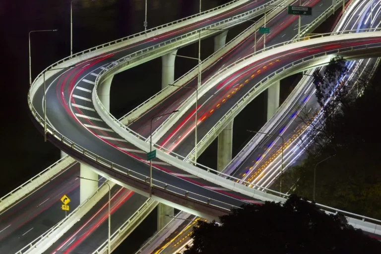A road at night lit up by car lights